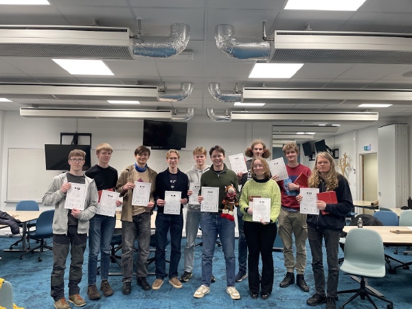 Deltakere står oppstilt med diplom og premie